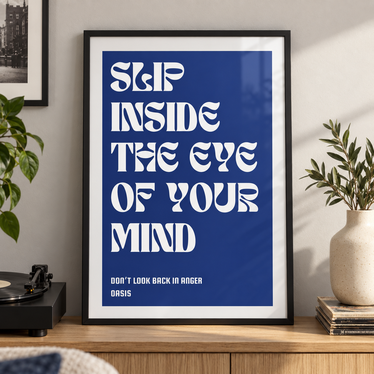 Don't Look Back in Anger Oasis lyric print in a black frame beside a record player