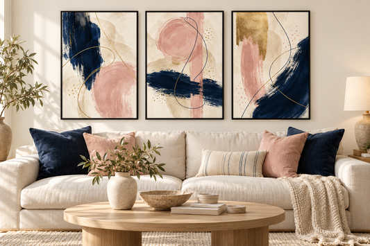 Navy blush and champagne abstract prints set of three in black frames above a sofa; frames not included