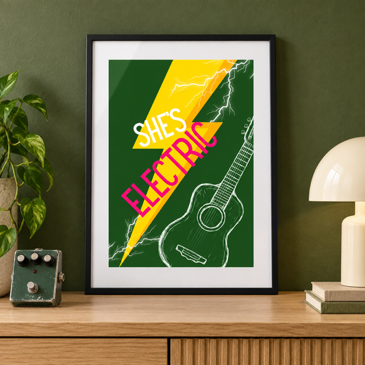 Oasis She's Electric green and yellow print in a black frame on a console