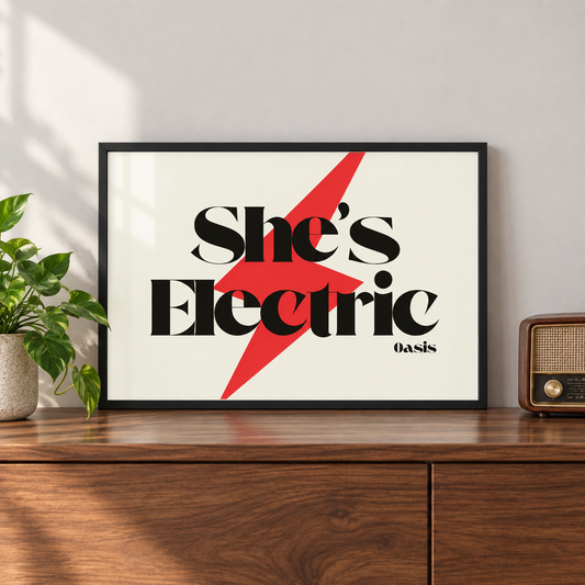 Oasis She's Electric lyric print in a black landscape frame on a walnut console